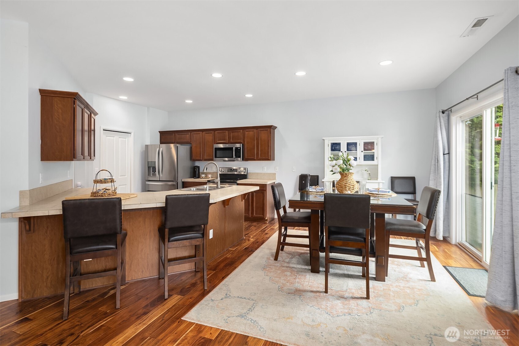 Thoughtfully open and beautifully connected, this living and dining space was designed for the way people want to live today. Expansive windows draw in natural light and frame the backyard, while the seamless flow between kitchen, dining, and great room creates an effortless setting for entertaining and everyday life. Spacious yet inviting, it’s a home that balances function, comfort, and relaxed Northwest living.