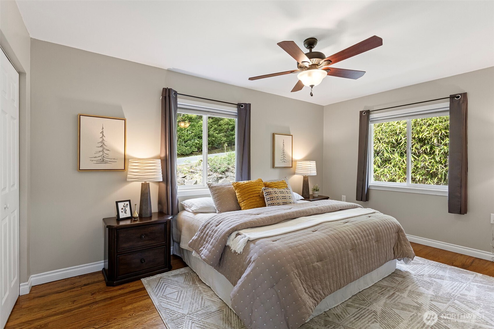Main floor bedroom with oak flooring and windows facing north and west. Ceiling fan for extra comfort and fresh paint.