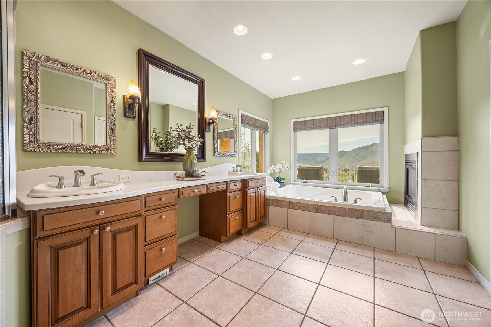 Spa-inspired primary ensuite offering both luxury and functionality, featuring dual vanities with abundant storage and generous counter space. Unwind in the oversized jetted soaking tub or enjoy the separate walk-in shower, complemented by a private steam room for a true at-home spa experience. Thoughtfully designed with tile flooring, ample lighting, and a bright, airy feel, this serene retreat elevates everyday living.