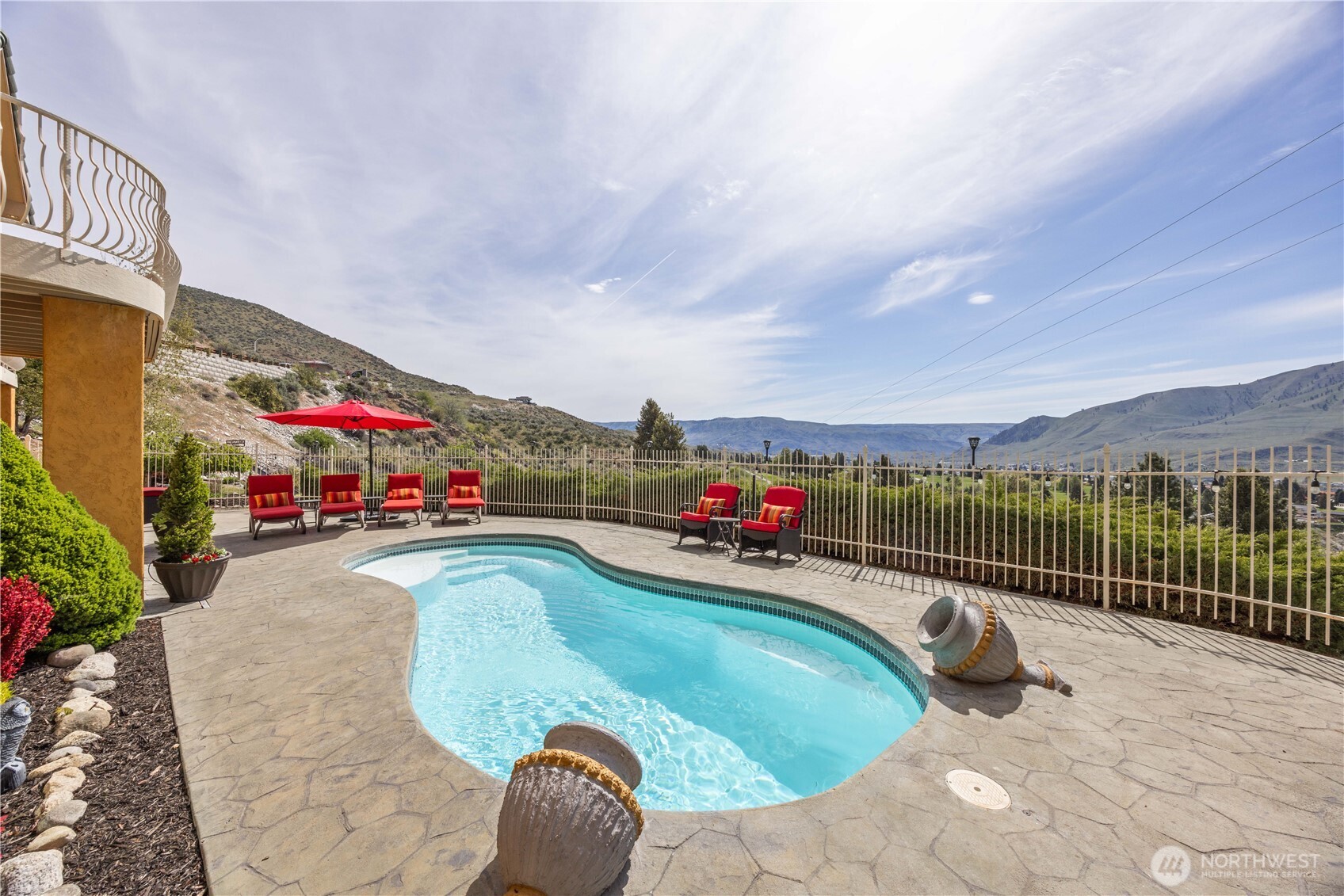 Resort-style outdoor living highlighted by a sparkling in-ground pool perfectly positioned to capture sweeping lake and mountain views. The expansive patio offers multiple lounging areas, ideal for entertaining or relaxing in the sun while taking in the serene surroundings. Thoughtfully designed for privacy and enjoyment, this exceptional outdoor space delivers the ultimate setting for unforgettable gatherings and peaceful evenings.