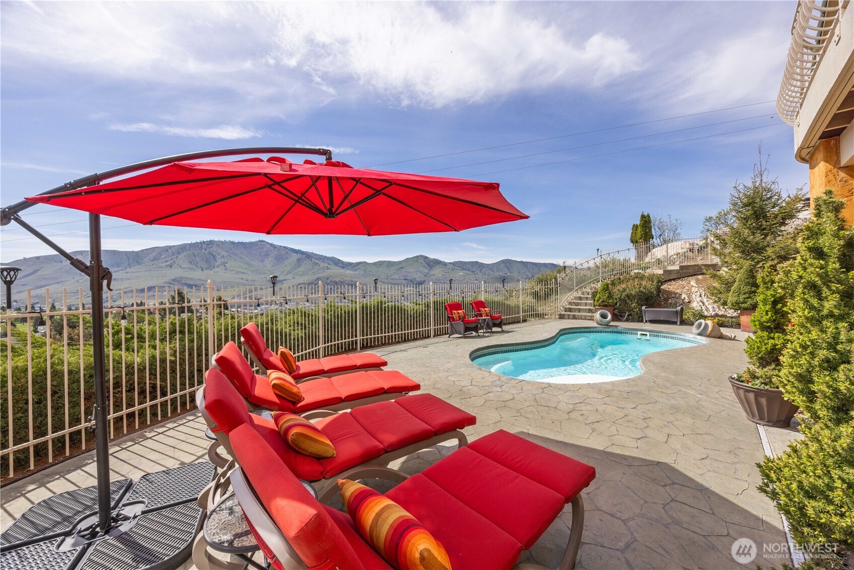 Vibrant outdoor lounge space designed to take full advantage of breathtaking lake and mountain views. The expansive patio features comfortable seating beneath a striking umbrella, creating the perfect setting for relaxing afternoons or evening gatherings. Elevated positioning offers a sense of privacy while capturing sweeping vistas, making this an ideal retreat to unwind, entertain, and enjoy the beauty of the surrounding landscape.