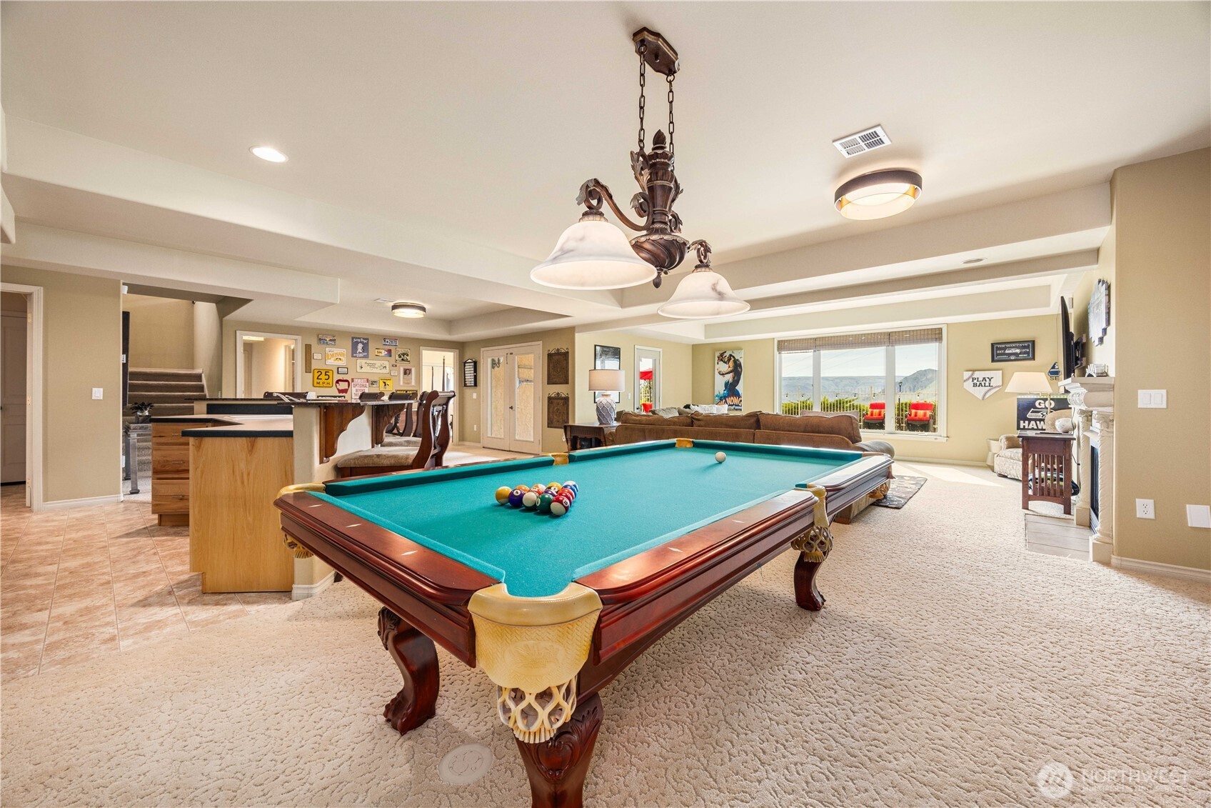 Expansive lower-level recreation room designed for entertainment and relaxation, featuring a full-size pool table and ample space for gatherings. The open layout offers flexibility for a variety of uses, whether hosting game nights, creating a media area, or adding a home gym. Warm finishes, built-in storage, and generous lighting enhance the inviting atmosphere, making this versatile space perfect for year-round enjoyment.