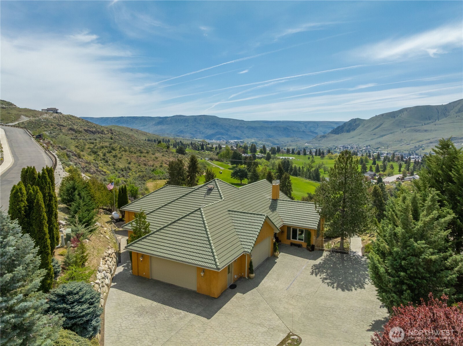 Perched above the valley in a premier hillside setting, this stunning property offers sweeping panoramic views of the surrounding mountains and lush golf course below. The beautifully maintained home features a spacious driveway, mature landscaping, and a sense of privacy while still being conveniently accessible. Enjoy breathtaking scenery in every direction, with elevated vantage points that capture the natural beauty and tranquility of the Lake Chelan area.