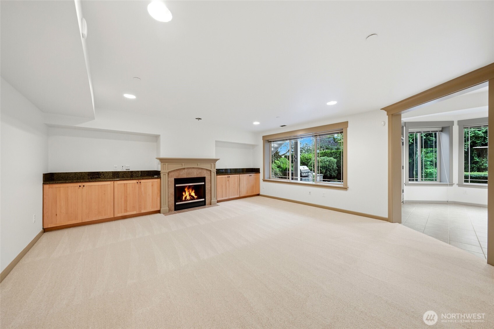 Lower level family room with a fireplace, open to the kitchen, dining area, then continues to the covered outdoor space with heaters, plumbed gas BBQ and the hot tub.