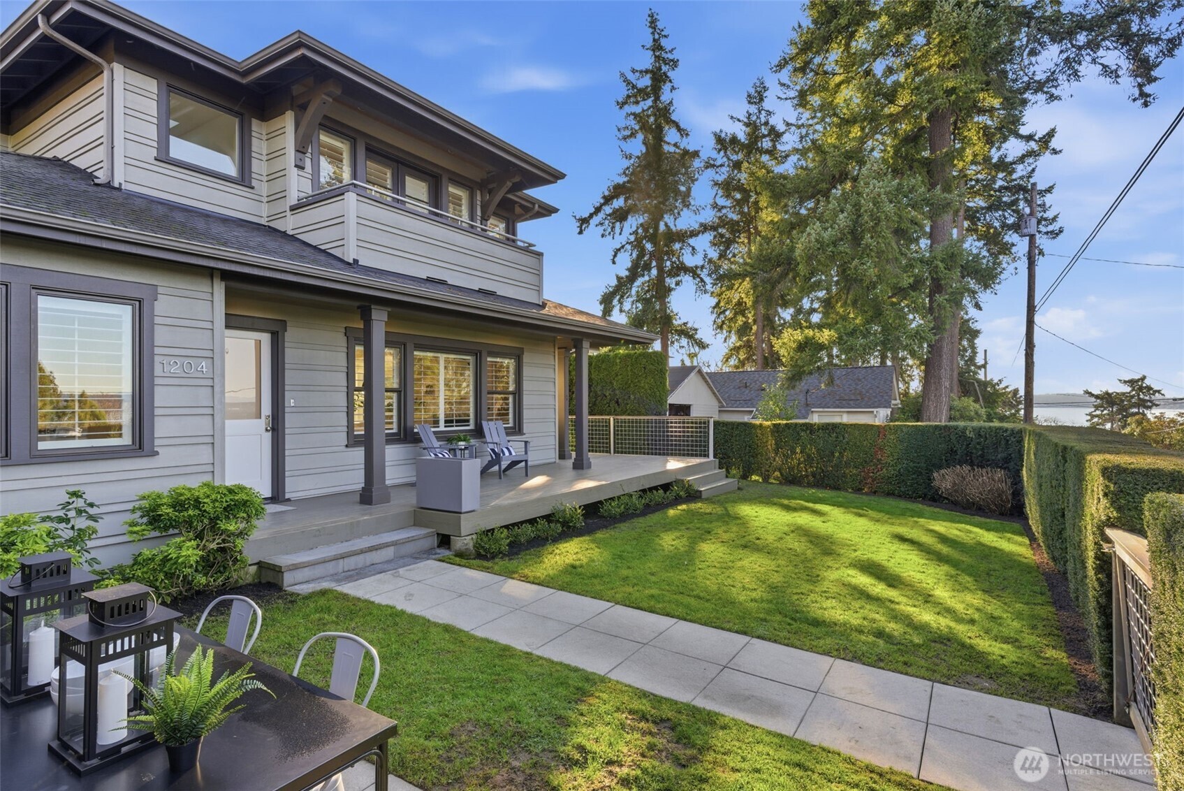 The yard receives equal parts sun and shade throughout the day, and the covered front porch affords year-round enjoyment of this blissful setting and Lake Washington views.