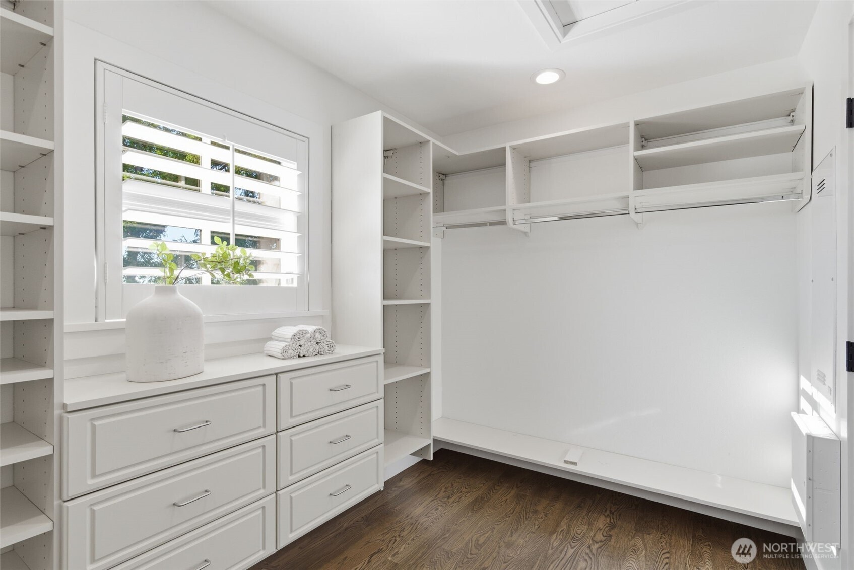 Lovely walk-in closet with hardwood floors and sweet awning window facing the lake.