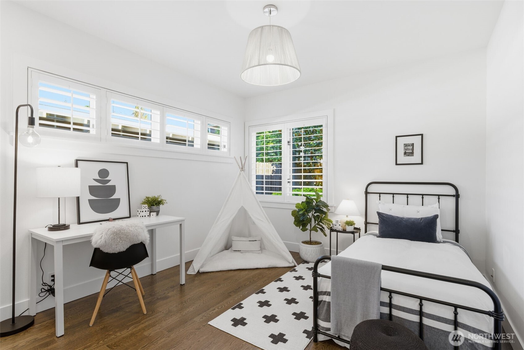 One of the spacious secondary bedrooms with high windows and sight lines to the magnolia trees.