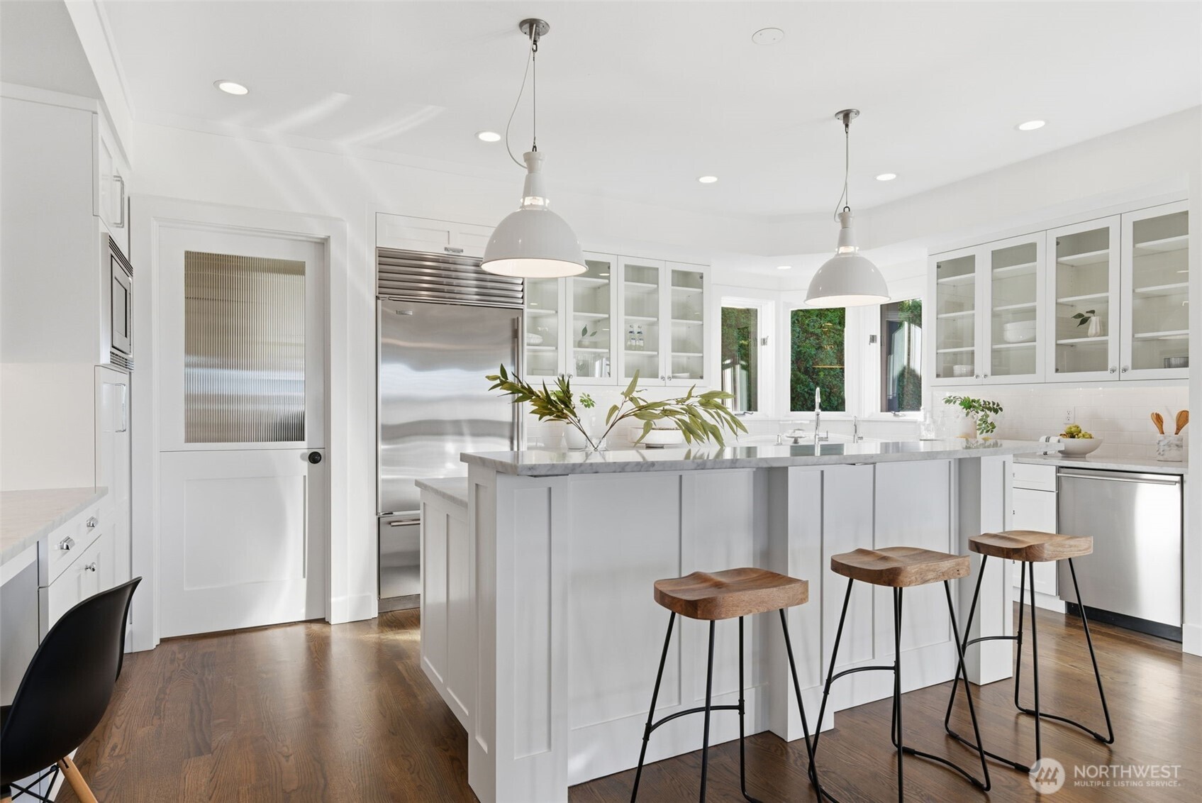 Subzero fridge and sweet custom Dutch-door with reeded glass upper leading to the mudroom and garage.