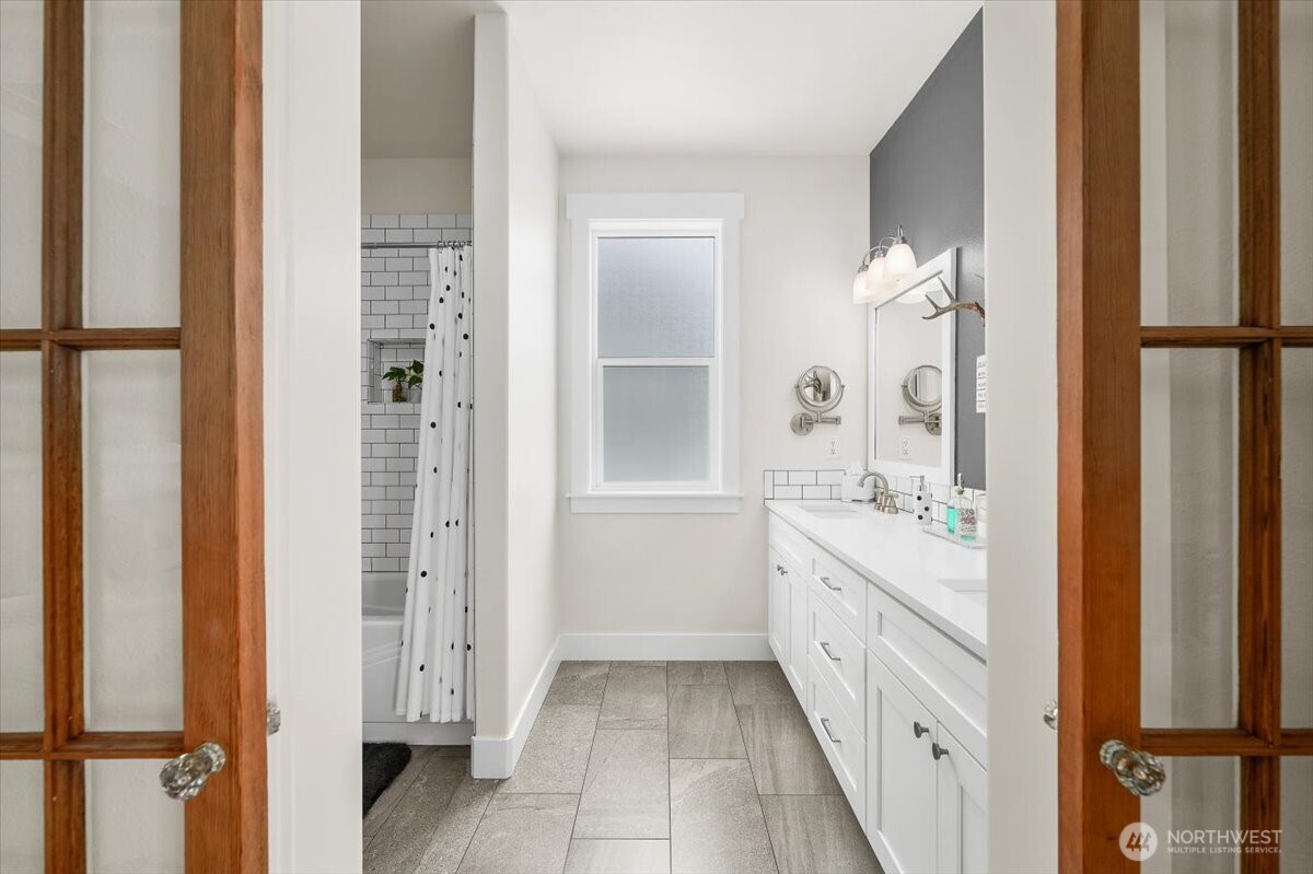 Spacious transition between the primary suite and ensuite bath creates an open, connected feel.