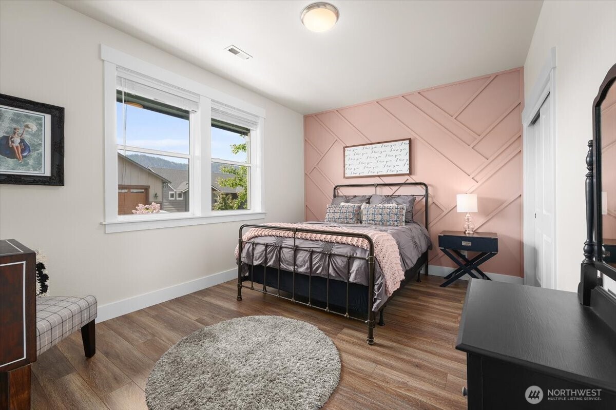 Lower floor front bedroom featuring custom accent wall details, warm natural light, and flexible space for guests, office use, or everyday living.