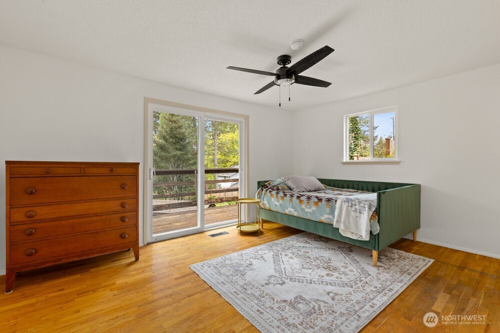 Main floor primary with original oak floors and slider to deck.