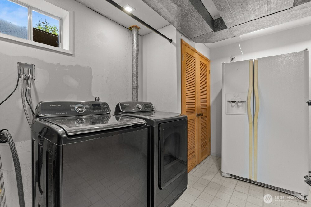 Generous laundry room with storage space and a fridge that stays.