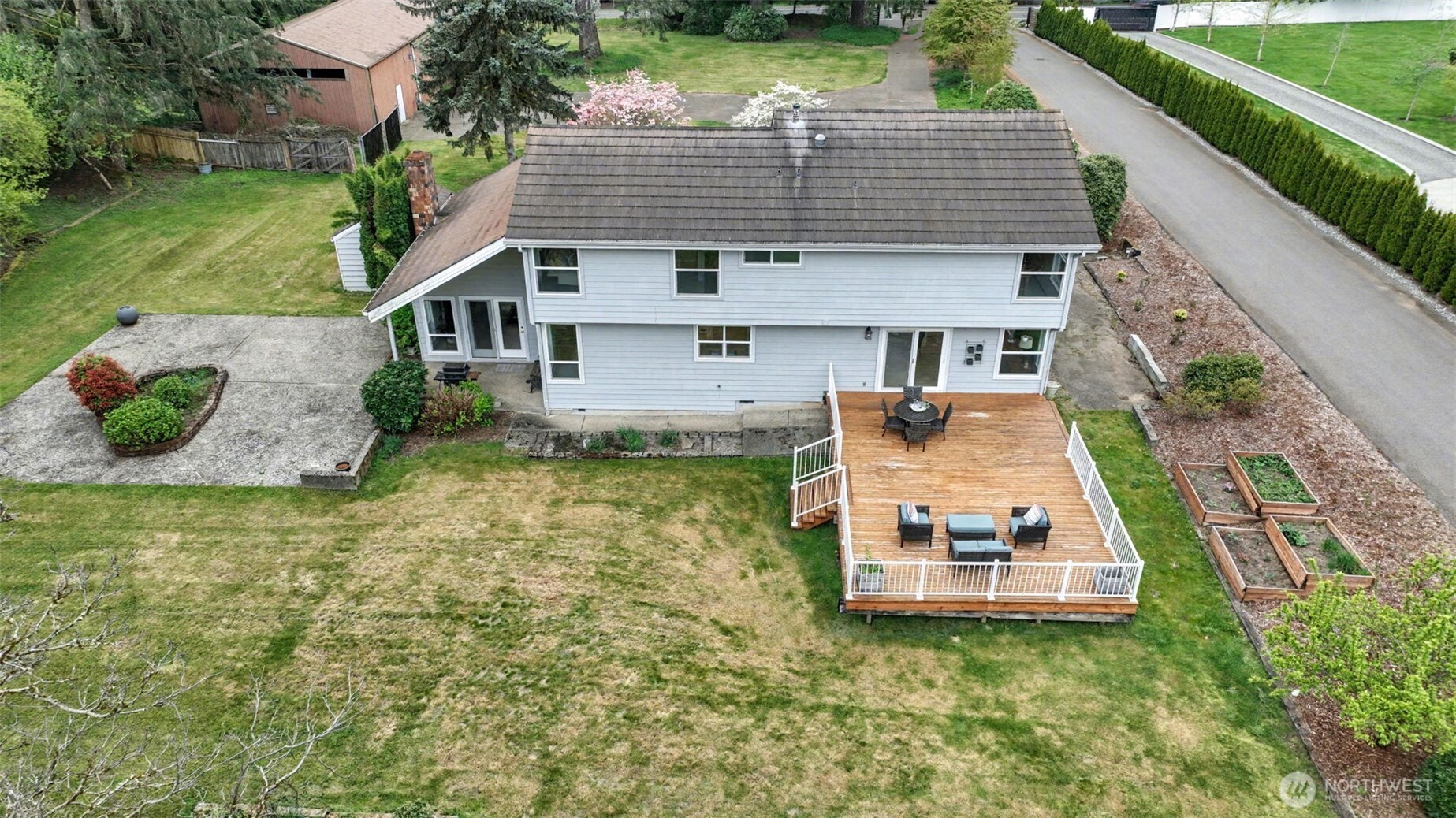 Over 1 acre of level yard with mature landscaping, planting beds, large deck, and patio.