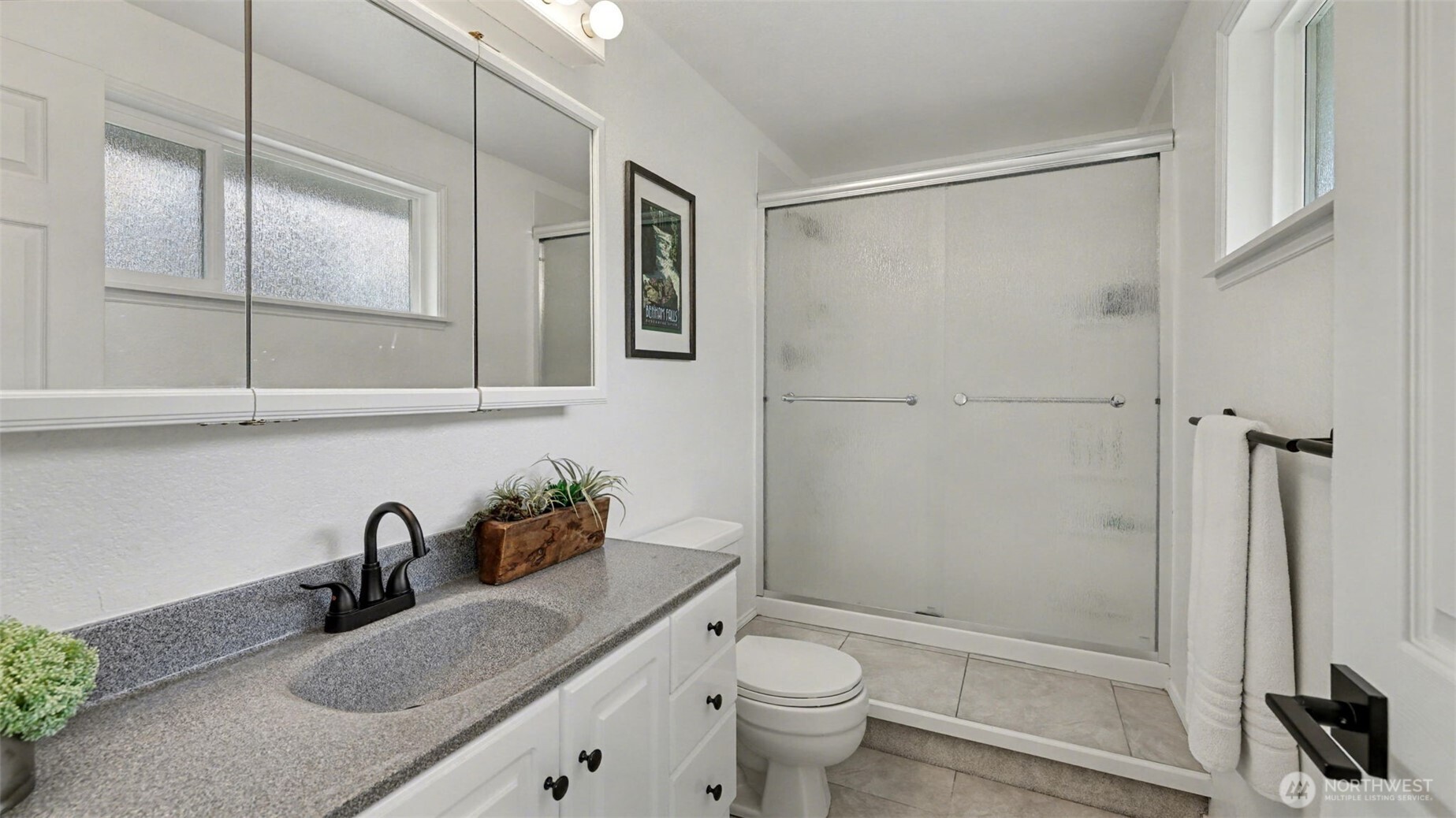 Primary bathroom features Corian countertops, tile flooring, and modern fixtures.
