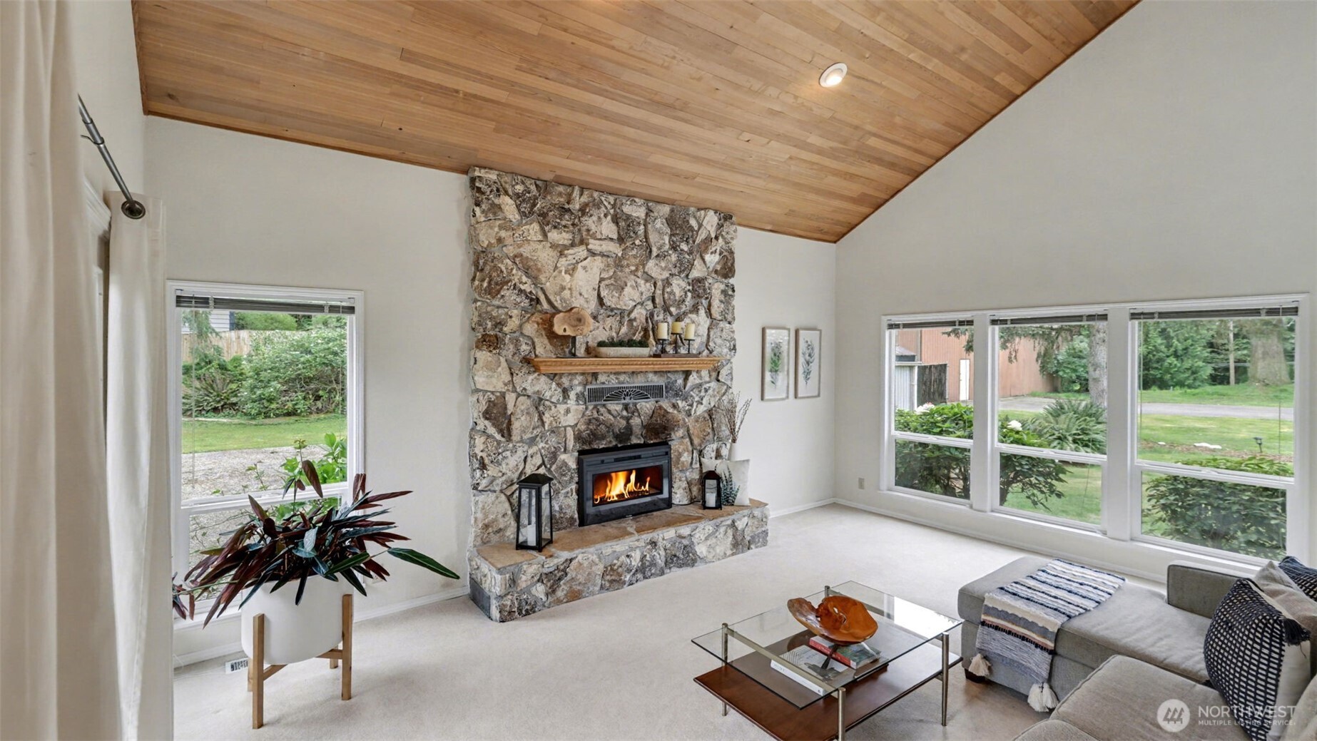 Vaulted ceilings and the floor-to-ceiling stone fireplace make a dramatic statement in the living room.