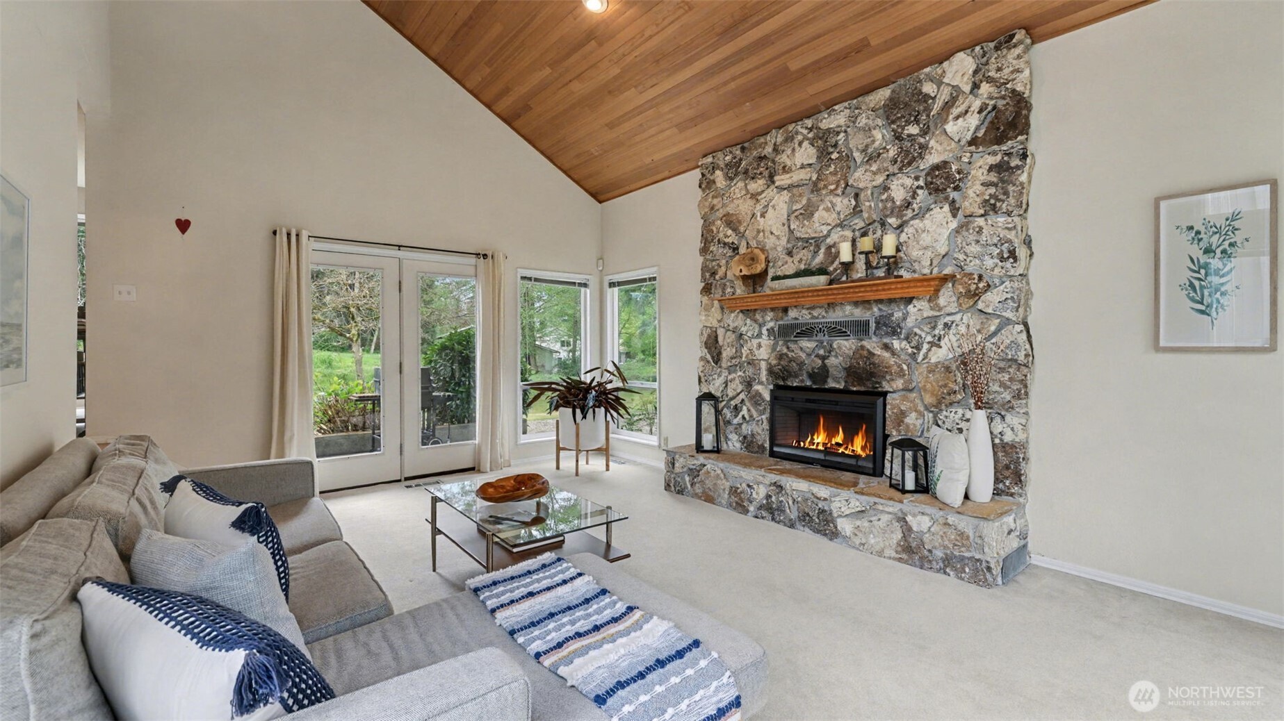 Walls of natural light surround this living room with French doors leading to the back patio.