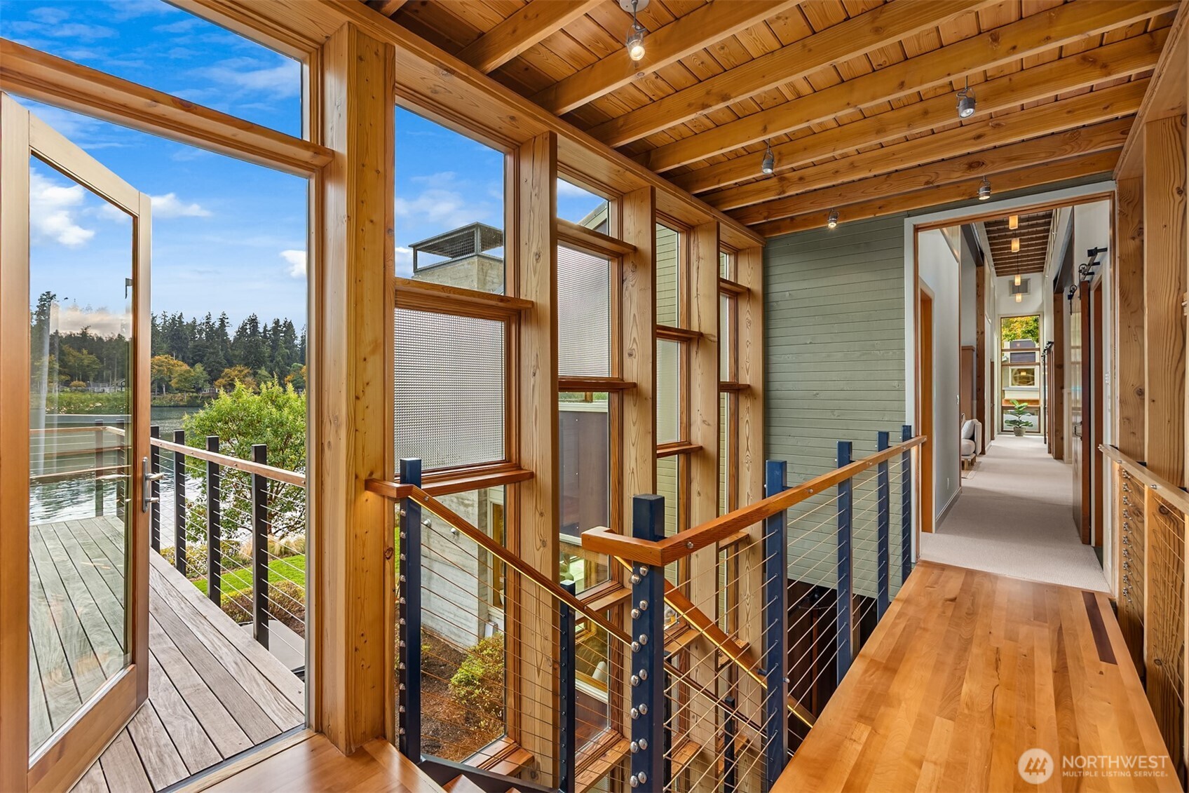 The upstairs landing opens to an ipe waterside deck adjacent to the primary bedroom suite.