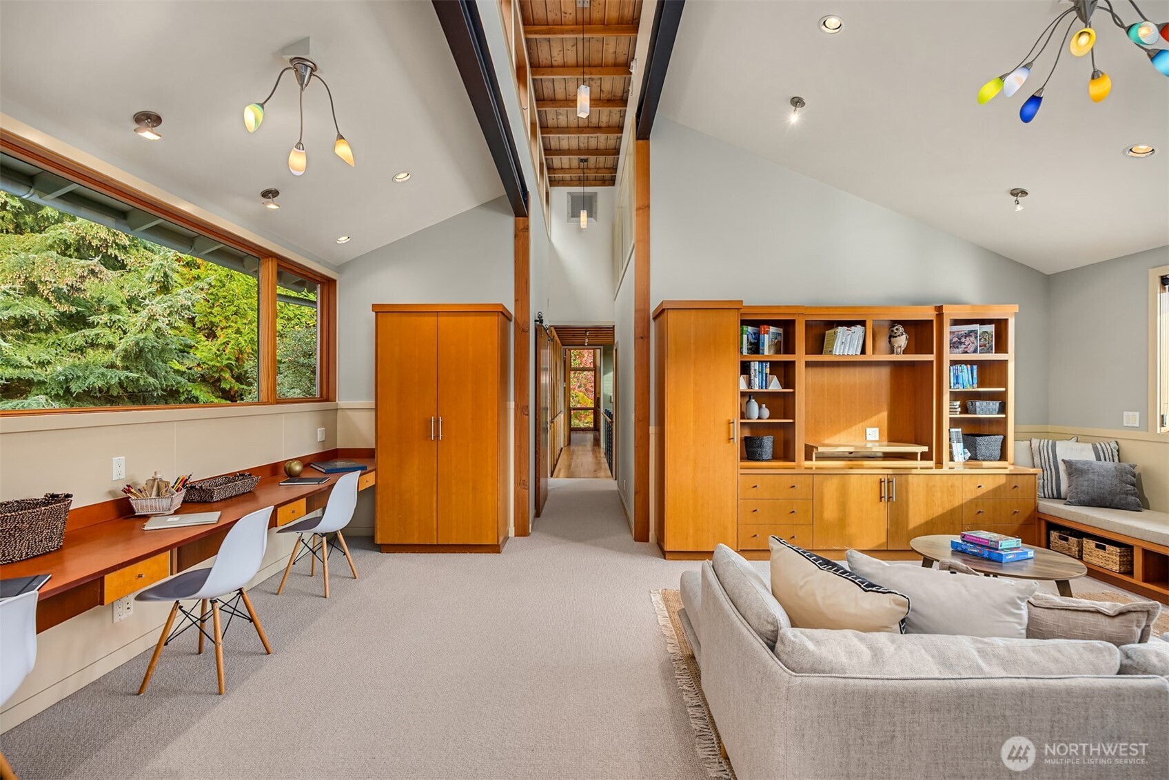 From the upper floor landing, a walkway leads from the primary suite to a separate bedroom wing with media/family room, utility room, three bedrooms and two full bathrooms.