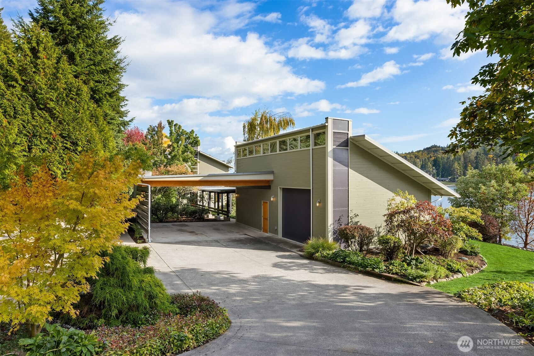 A paved driveway leads to the 2-vehicle carport, one-car garage, and overflow parking.