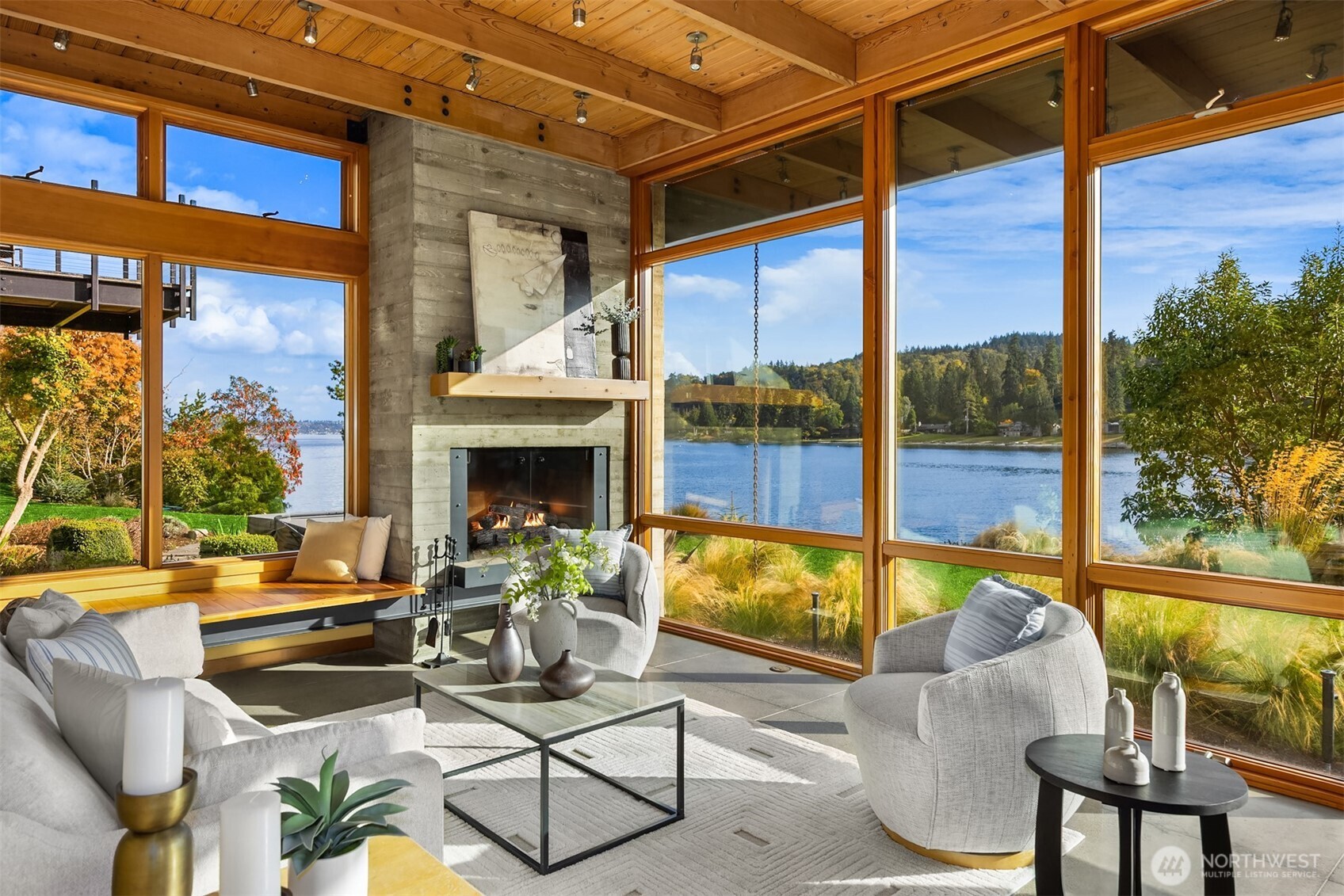 A deep built-in bench and sculptural steel-and-concrete fireplace form the heart of the room.