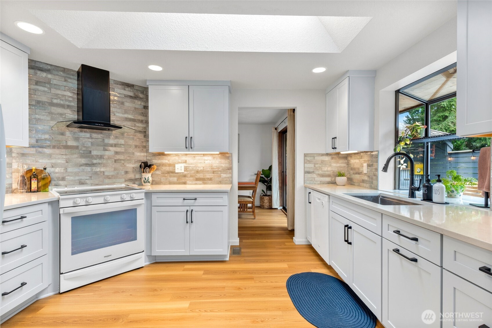 Fully remodeled kitchen with quartz countertops and custom tile backsplash