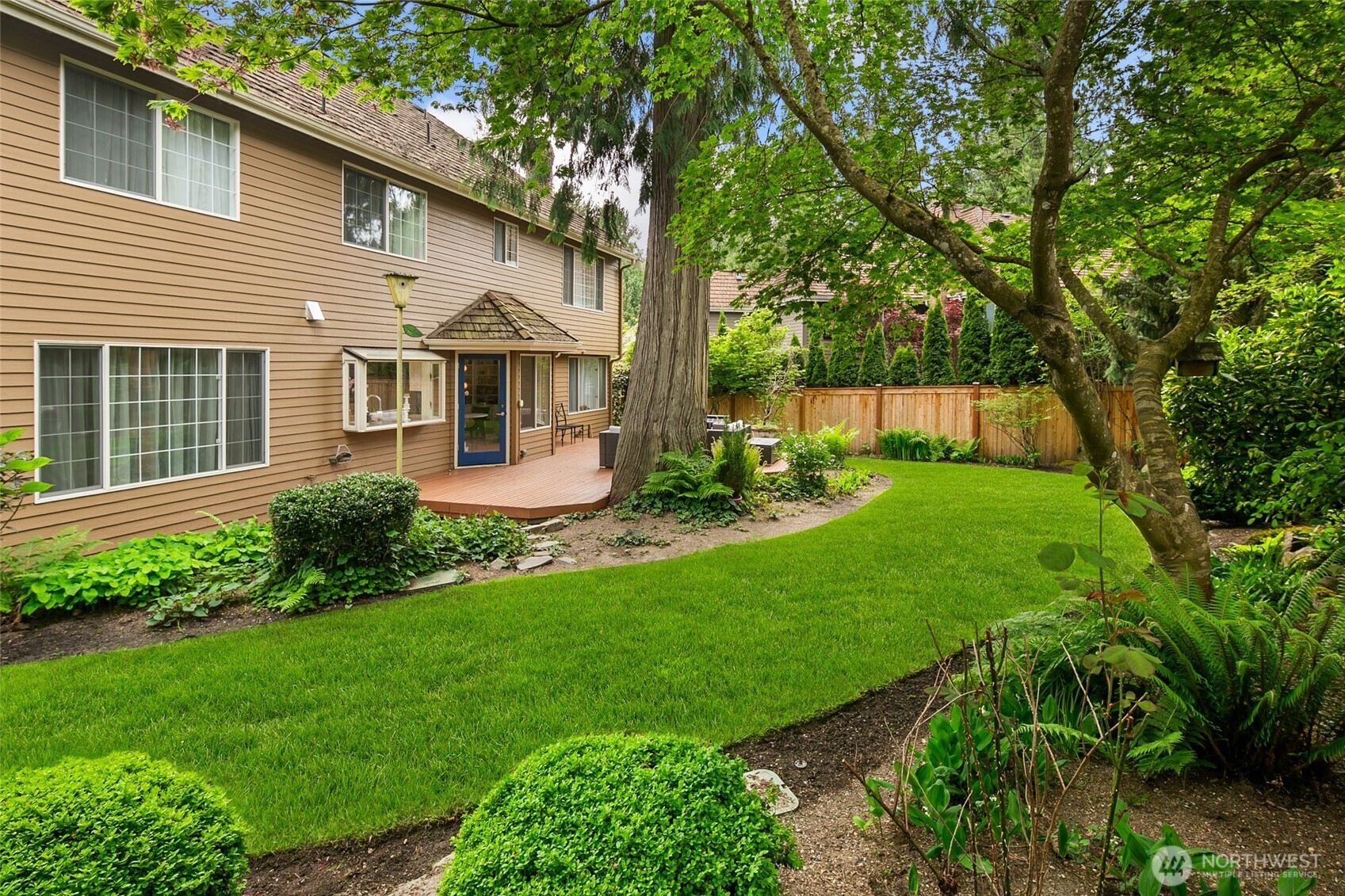 mature landscaping, manicured garden beds, a new deck, and new fencing create a manicured private garden setting for relaxed afternoons, outdoor dining, and effortless entertaining.