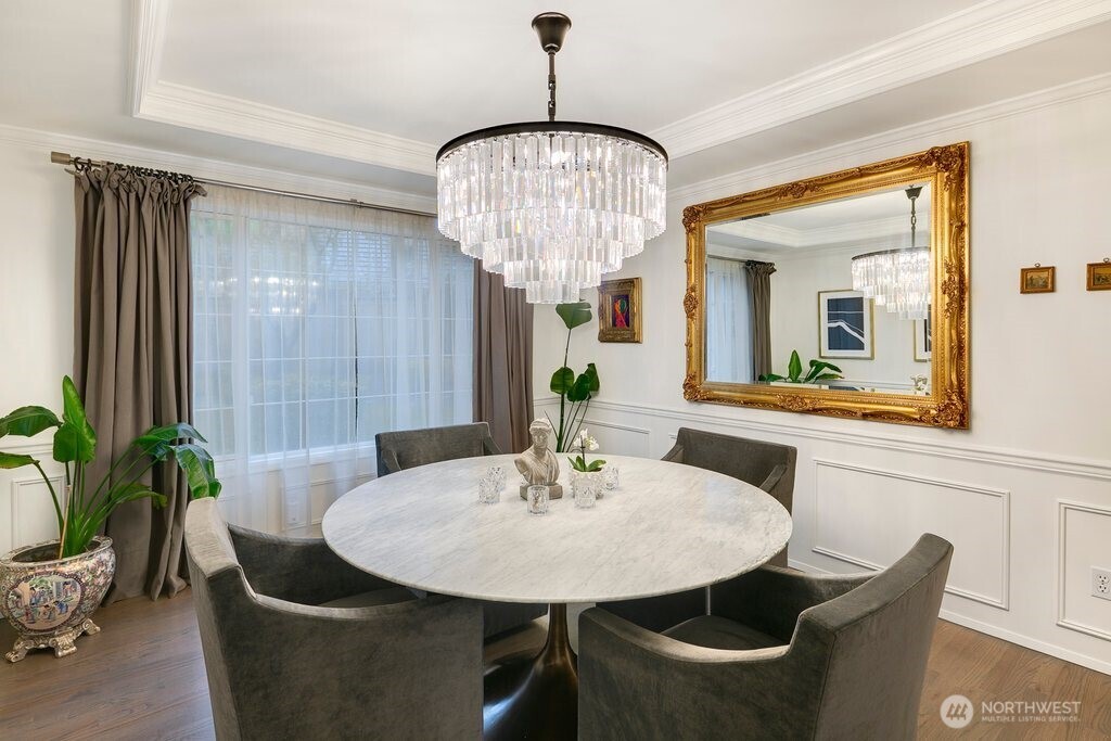 The kitchen was fully reimagined as an elegant gathering space with custom cabinetry, porcelain countertops, a central island, a custom-designed range hood, and professional-grade venting.