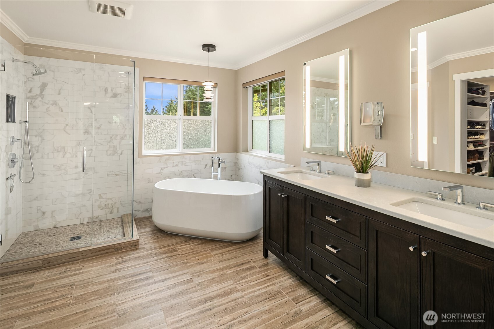 Fully remodeled spa-inspired bath with custom closet, freestanding tub, tile shower, heated floors and mirrors, and dual vanities.