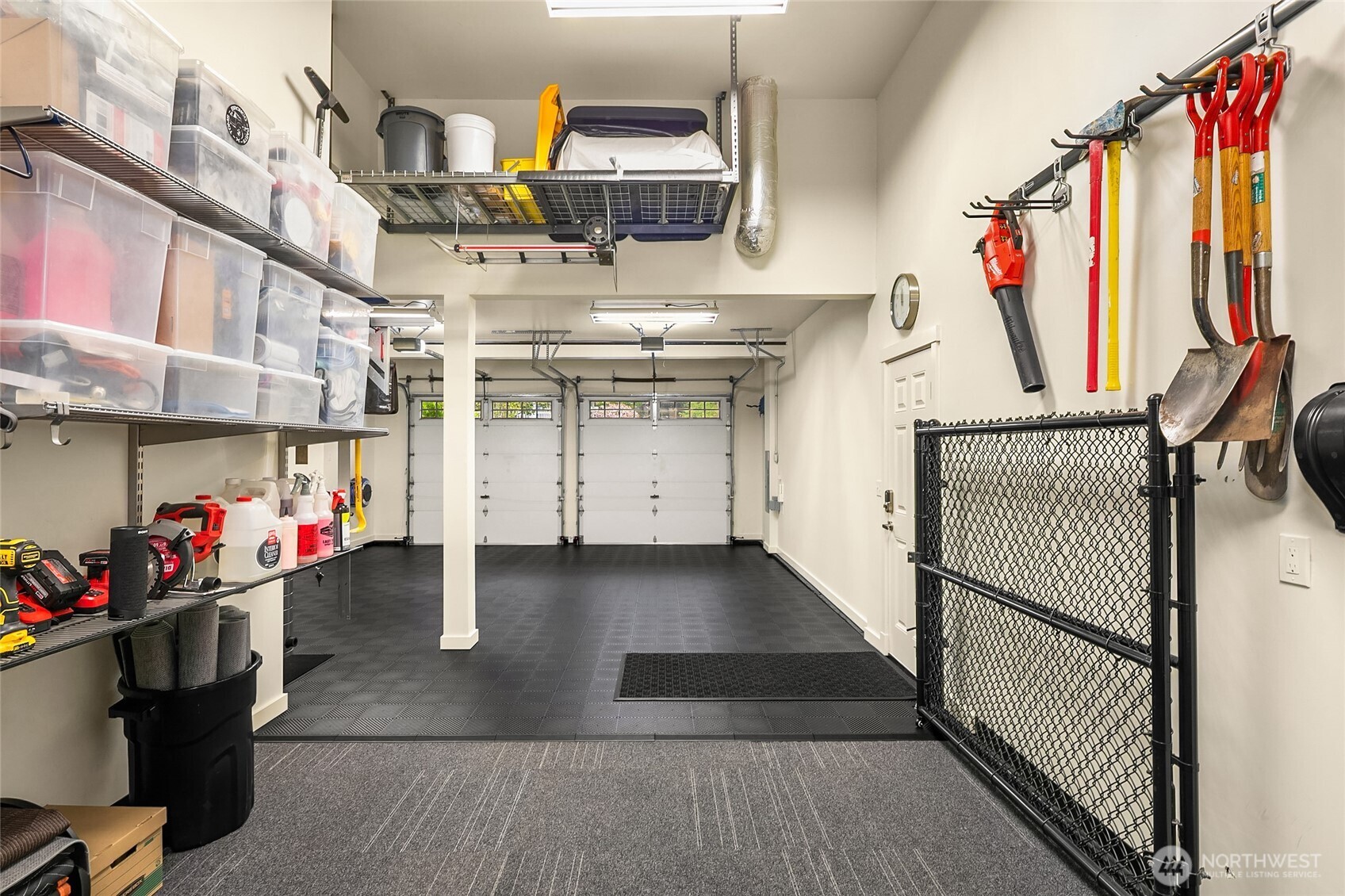 Outstanding three-car garage with high ceilings, bright lighting, custom flooring, secure storage and workspace.