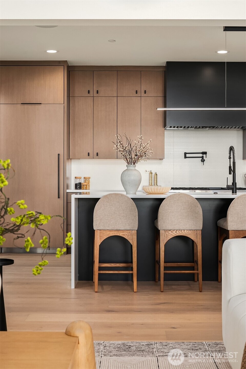 Kitchen flows seamlessly into the dining area with soaring ceilings and abundant natural light.