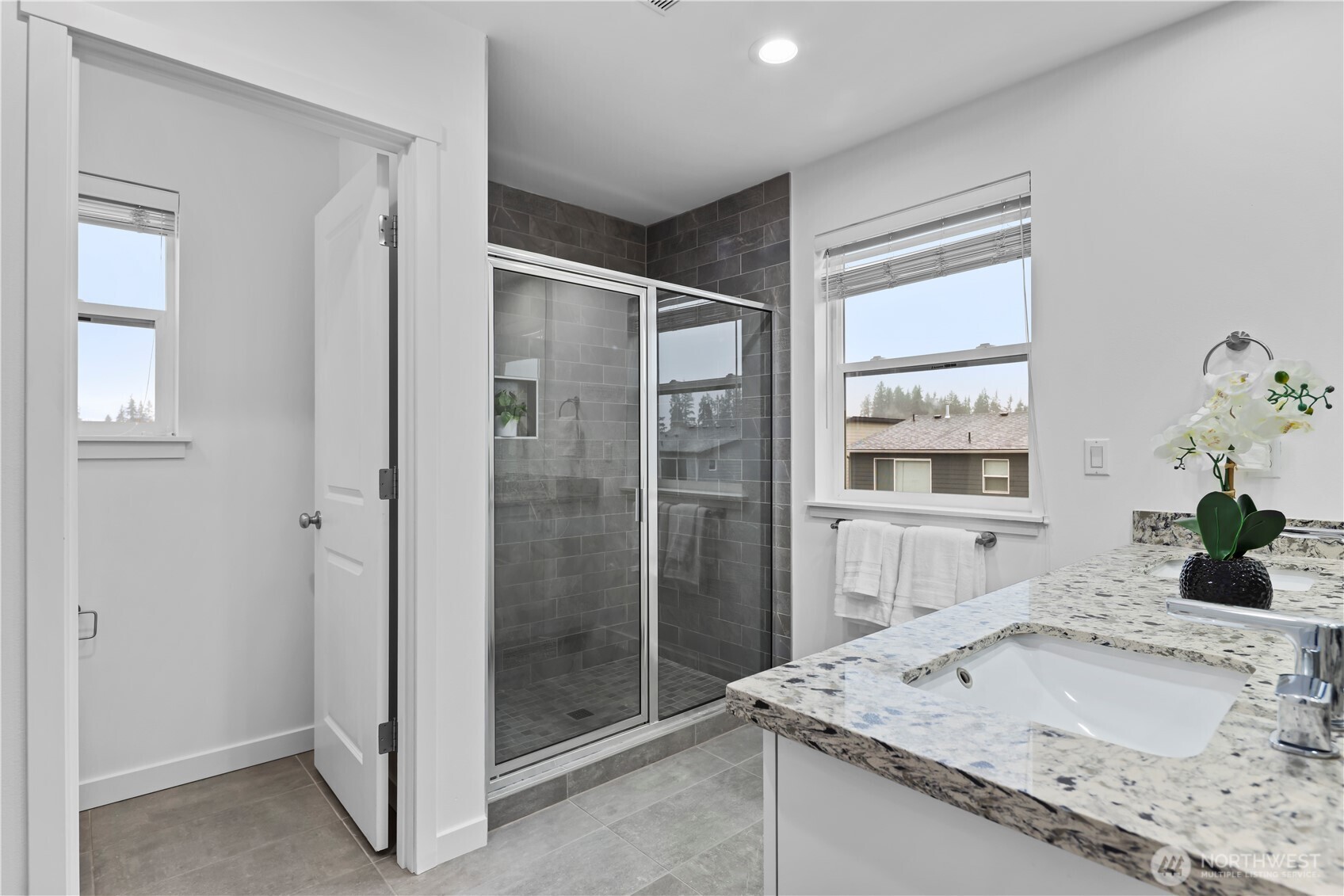 Primary ensuite with water closet, tiled shower, and double vanity.
