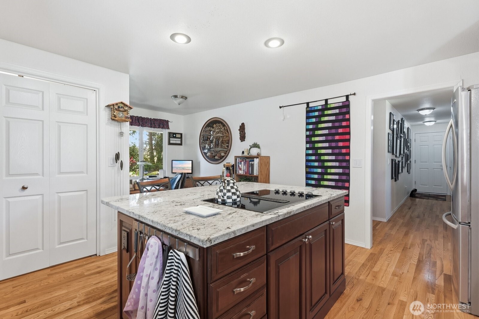 The large kitchen island with slab granite serves as the perfect hub for meal prep and casual entertaining.