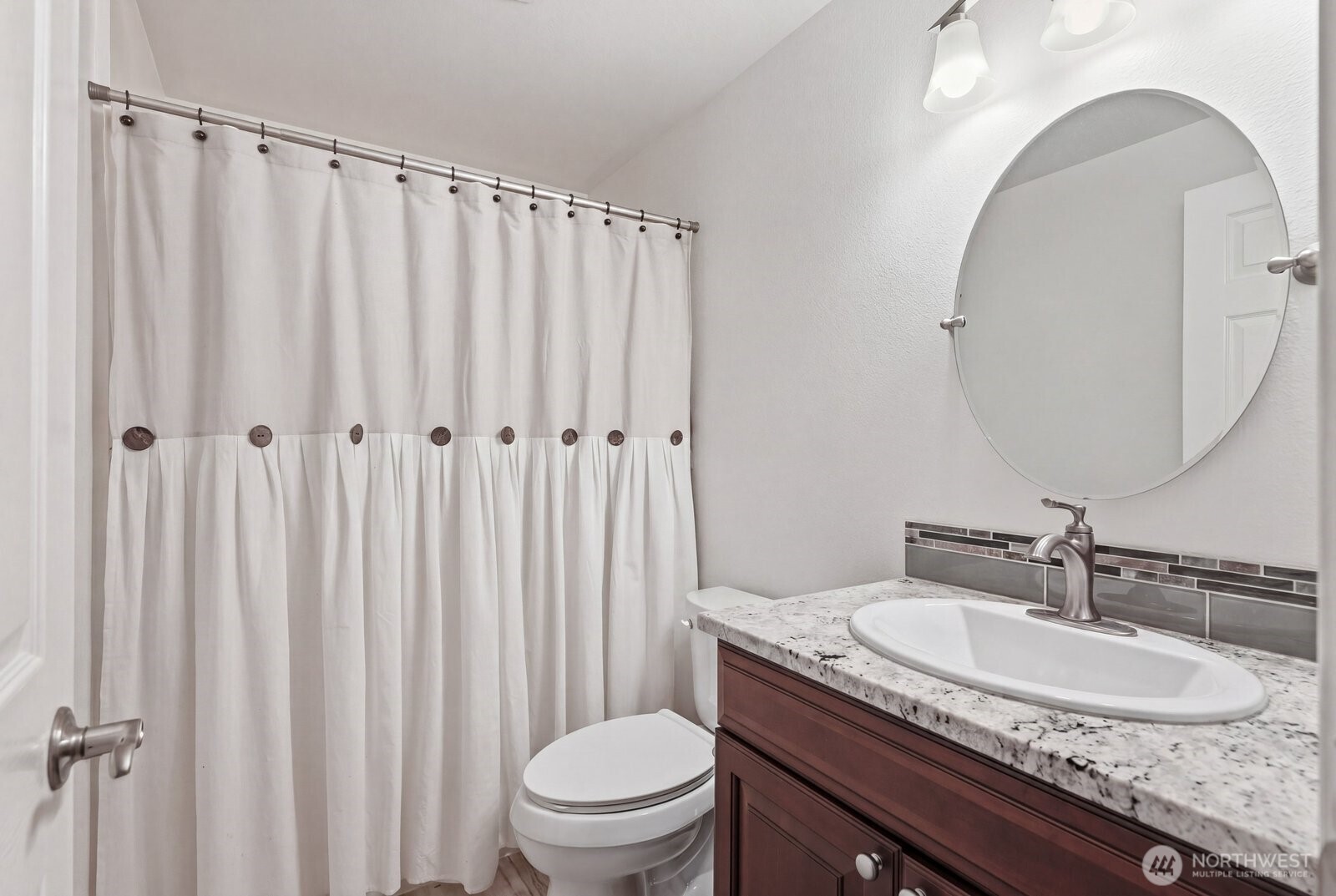 The hallway bathroom features slab granite counters and a deep tub for soaking.