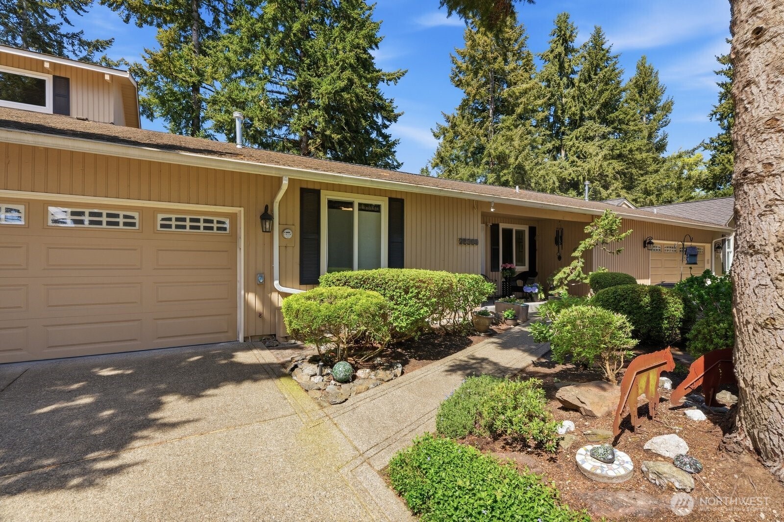 Enjoy the serene view of vibrant garden beds from your front porch—a perfect setting for your morning coffee.