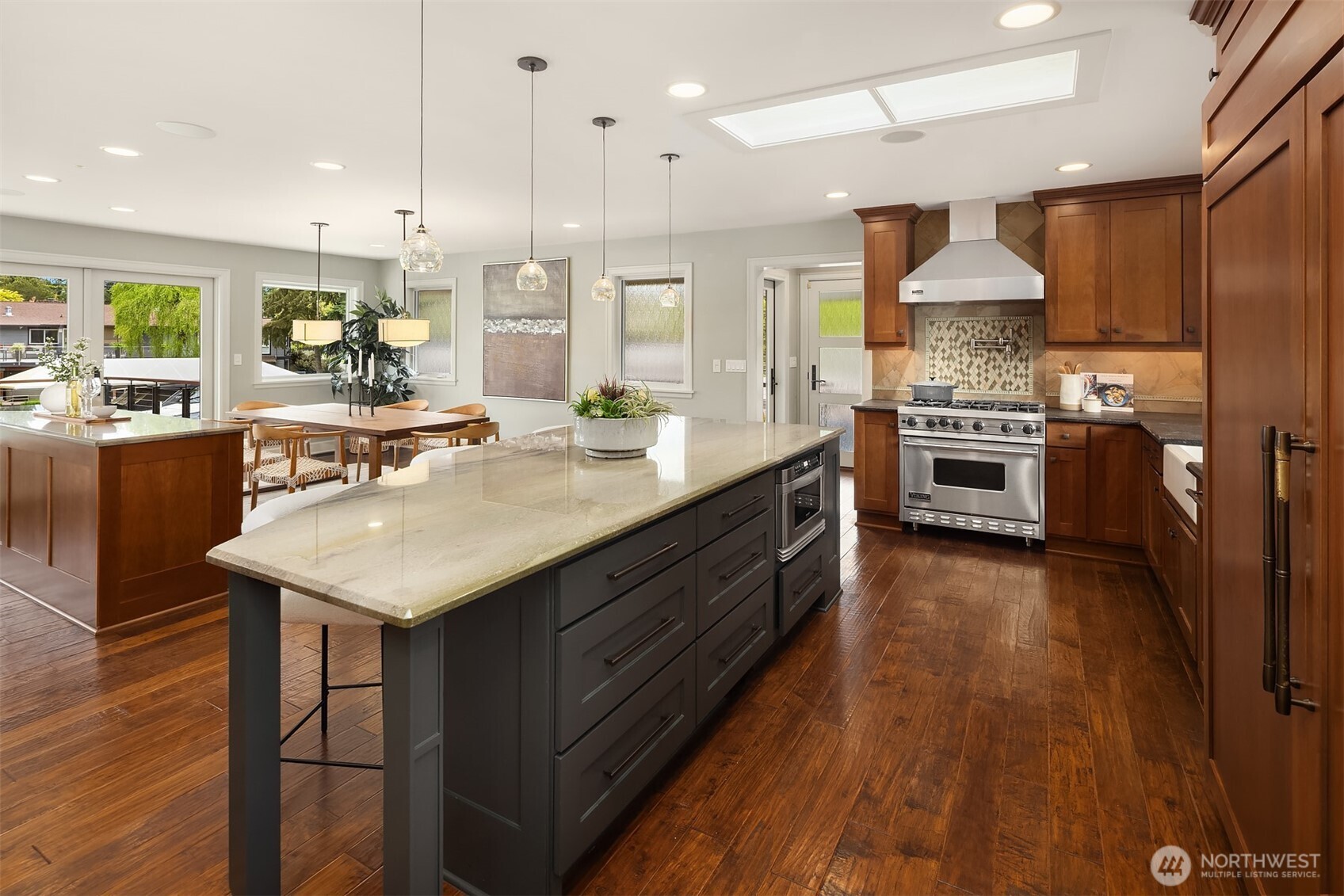 Two skylights draw in natural light, while pendant lighting defines the space below—creating a kitchen that feels open, warm, and always in motion. From weeknight dinners to full gatherings, everything flows with ease.