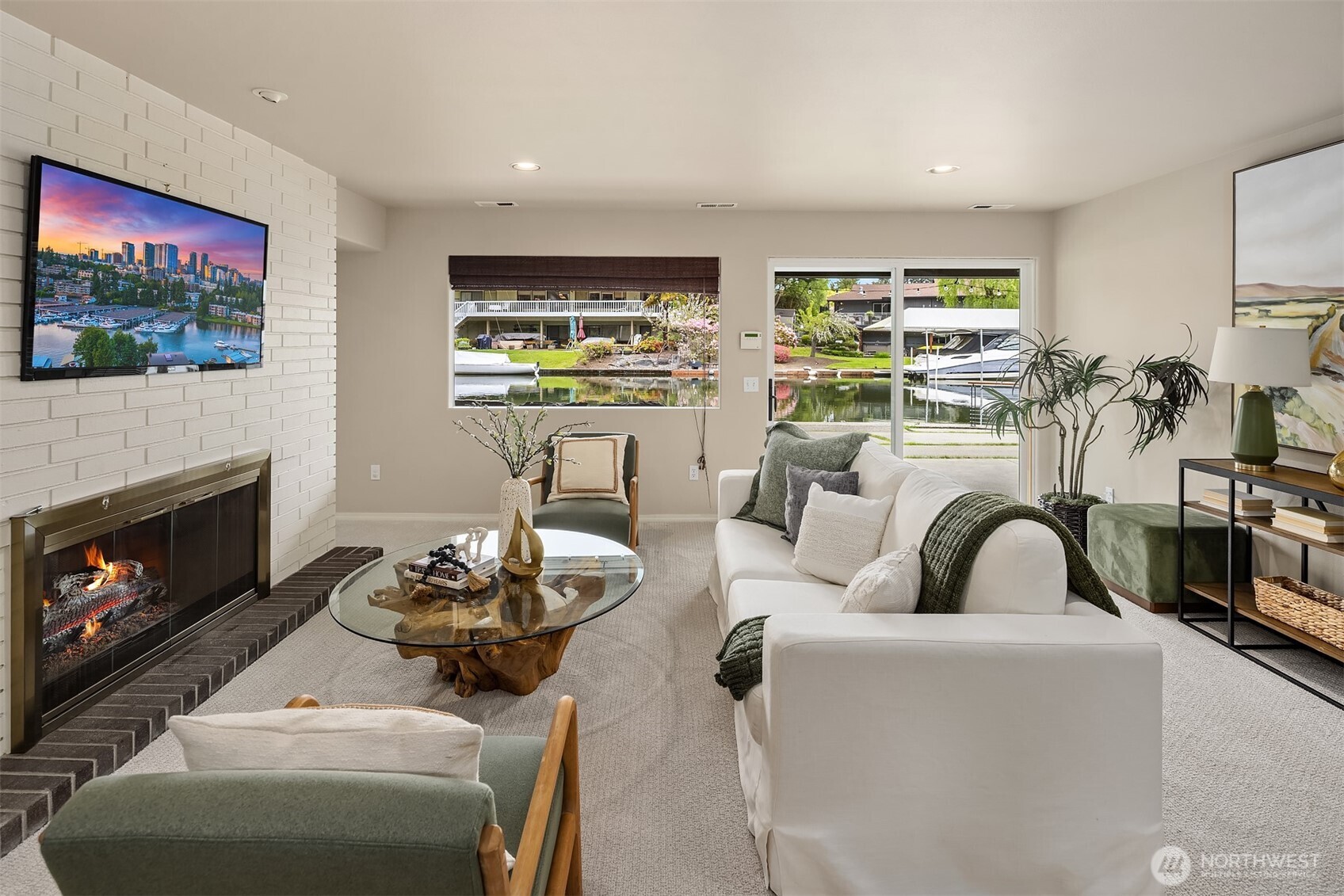 A relaxed, waterfront rec room made for movie nights, game days, and easy gatherings—where the fireplace adds warmth and the canal just beyond keeps the setting effortlessly connected to the outdoors.