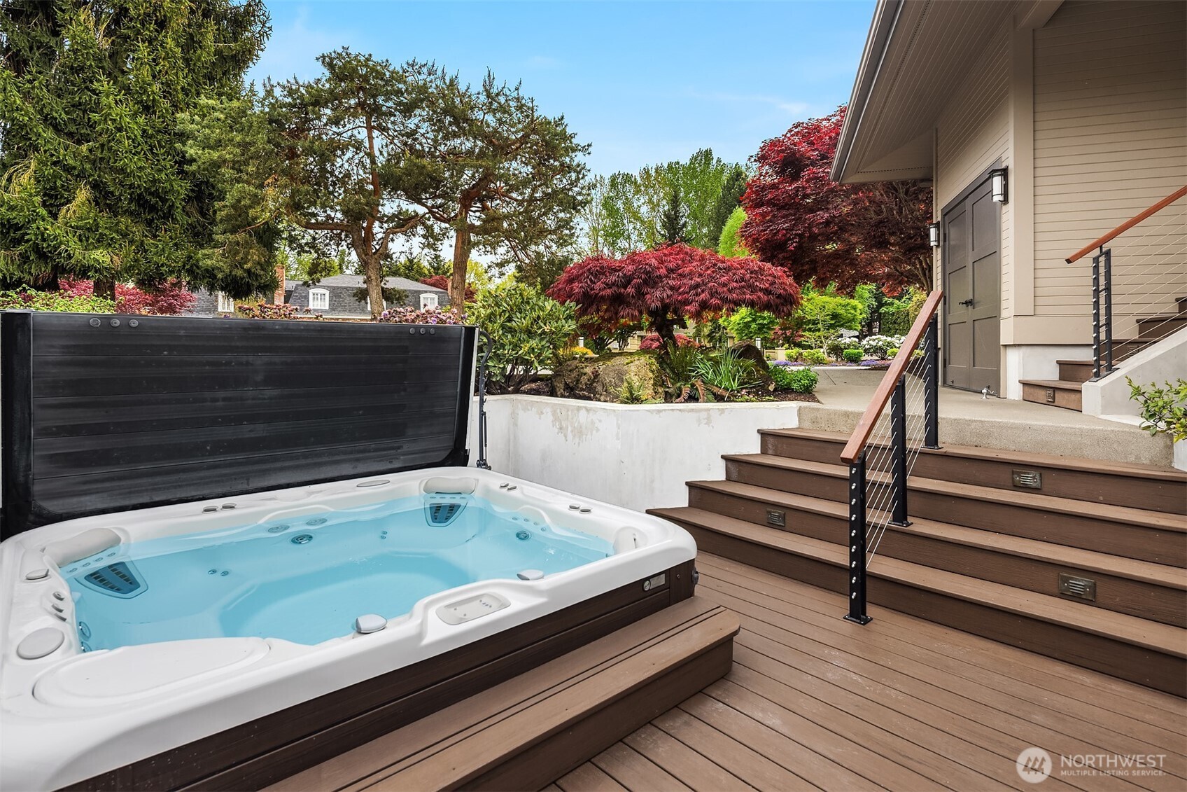 Tucked within the decking, the spa becomes a daily ritual—morning reset or evening unwind, surrounded by greenery and the calm of the water just beyond.