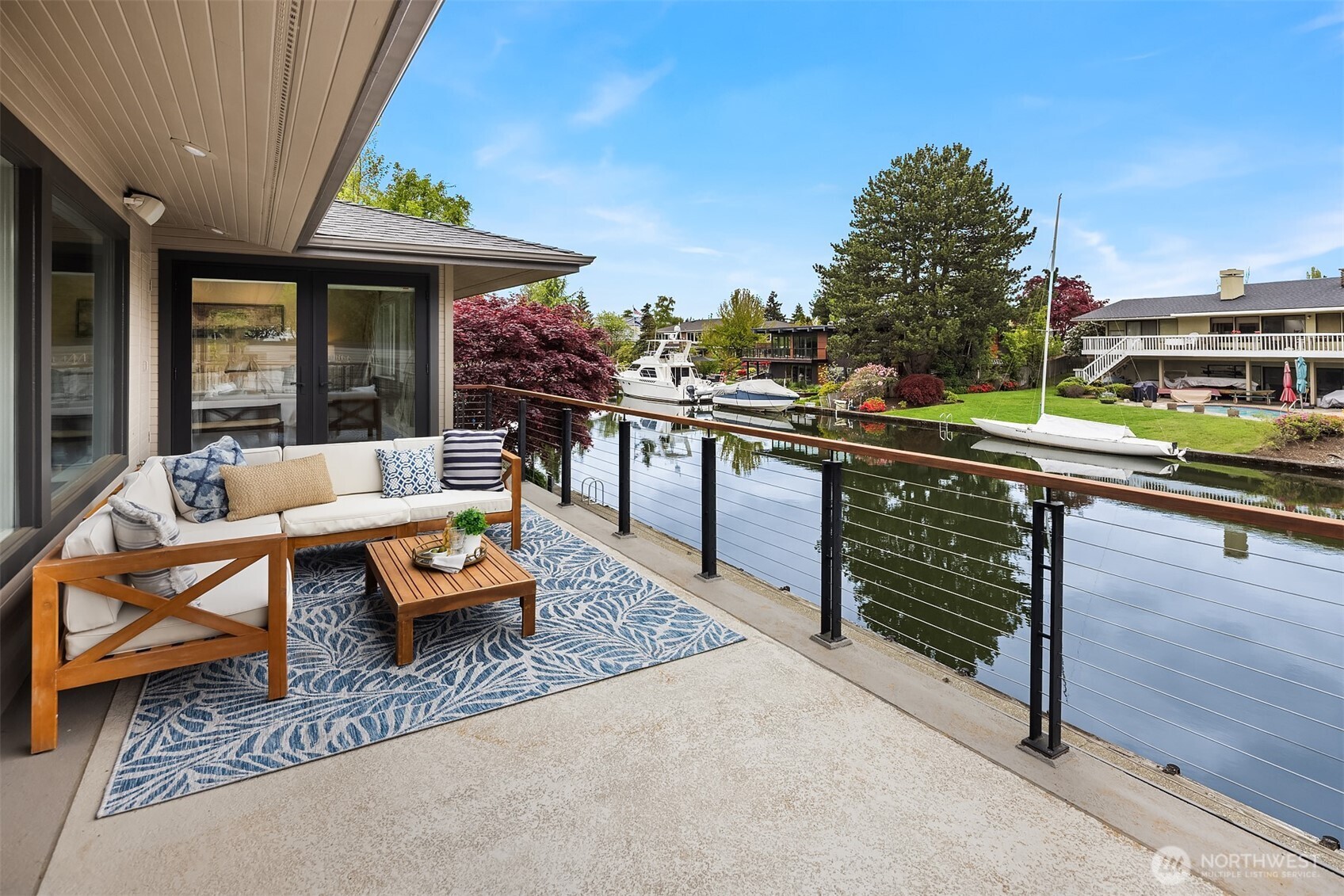 As the light softens, this becomes your place to unwind—book in hand, a glass of wine within reach, and the quiet rhythm of the water just beyond. Sunsets linger here, casting a warm glow across the canal—just steps from both the primary suite and main living spaces, creating an effortless connection between indoors and out.