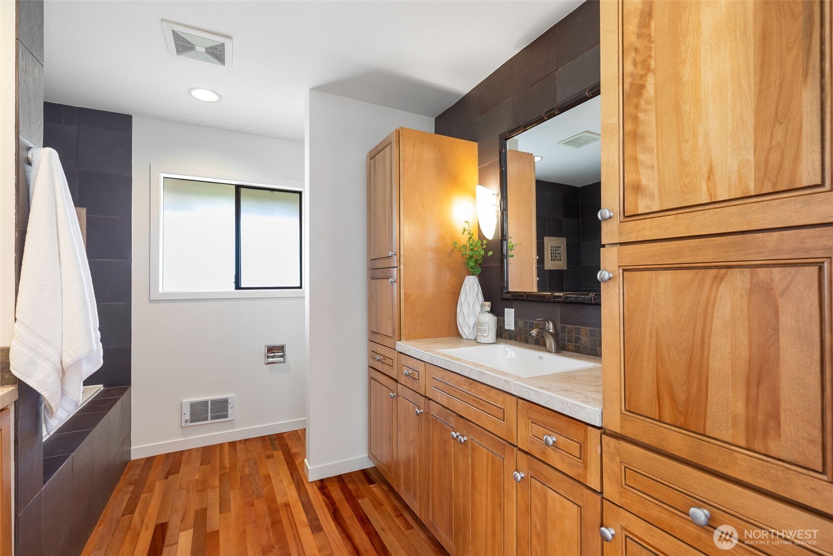 Hallway bath with soaking tub, divided toilet area, and plenty of storage