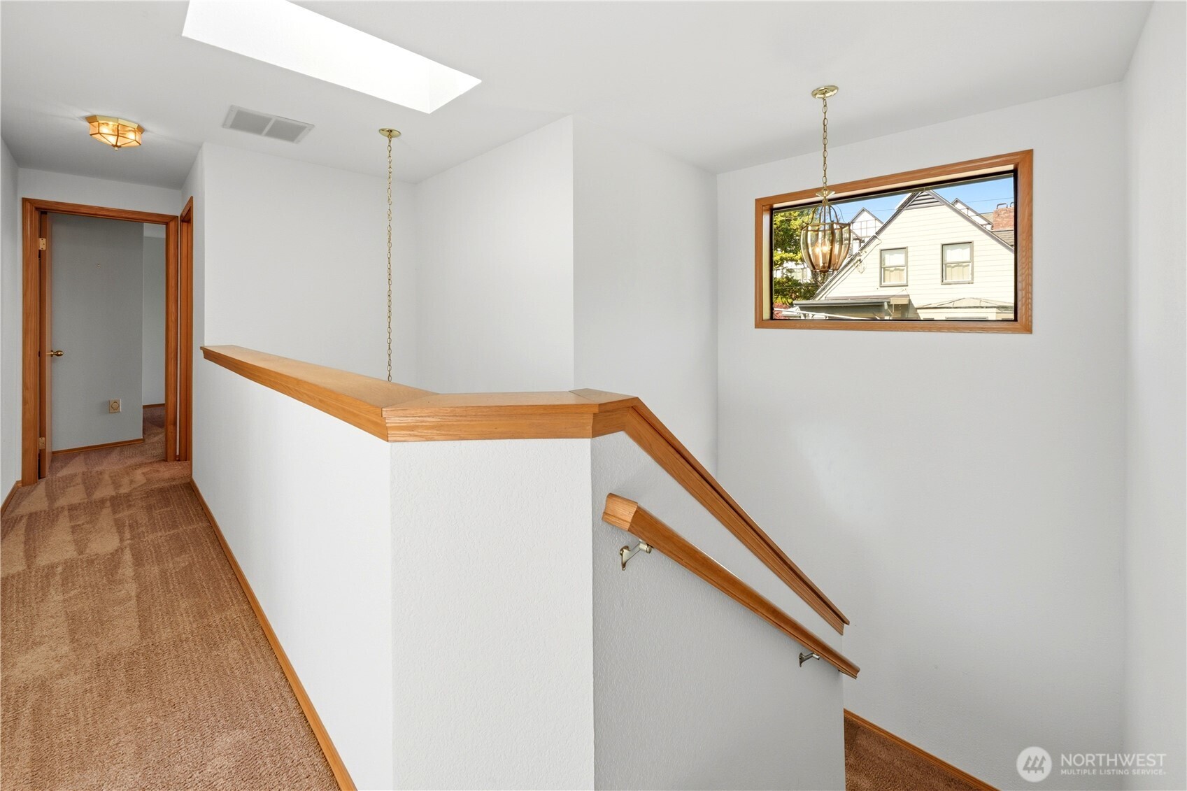Top of stairway looking down the hall to the 3rd bedroom at the end. Full bathroom is on the right before the bedroom.