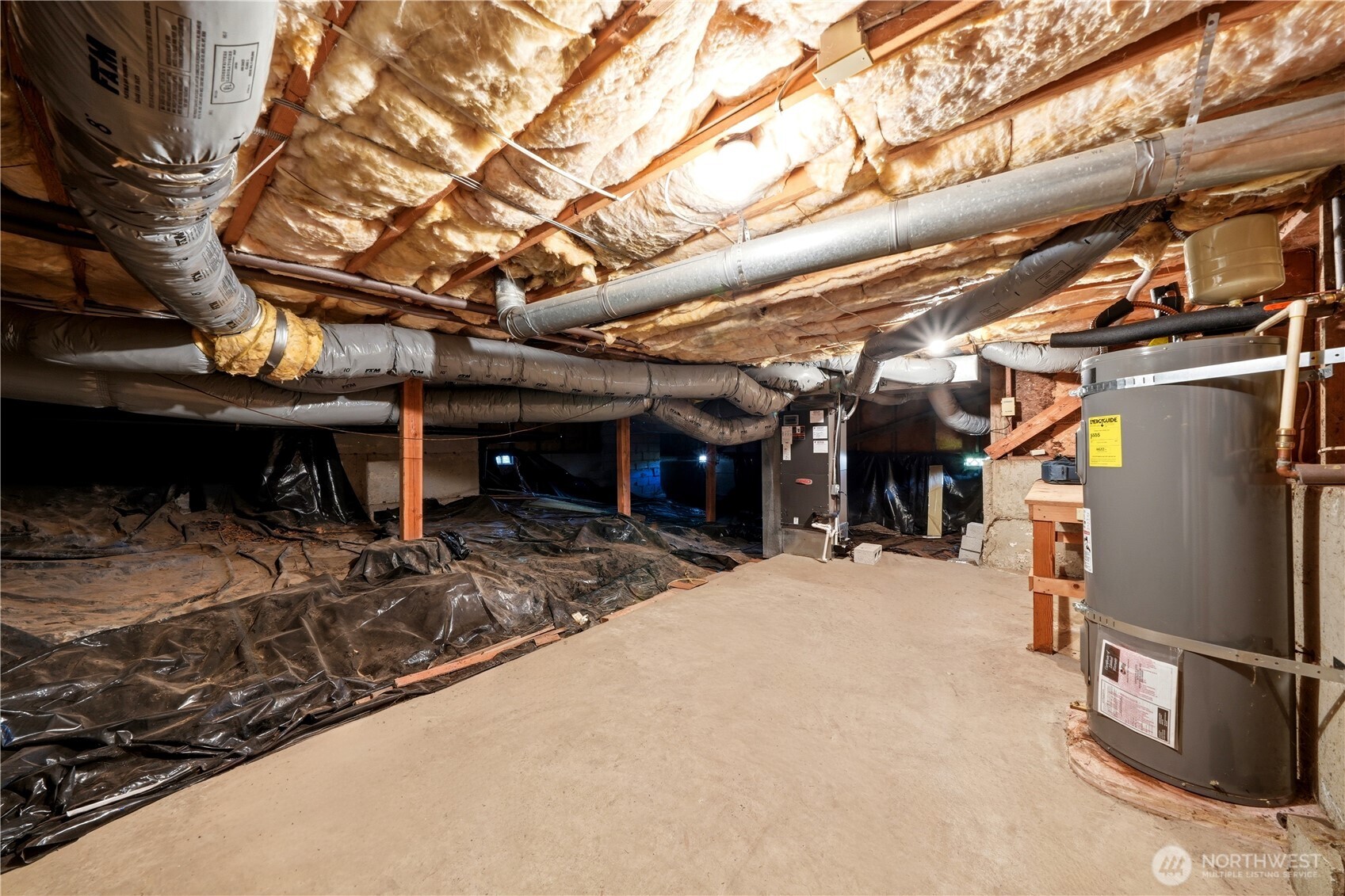 Insulated like crazy! Here is where the hot water tank and the furnace are situated on a concrete floor. There is also a workbench past the hot water tank to the right. Head height is good down here.