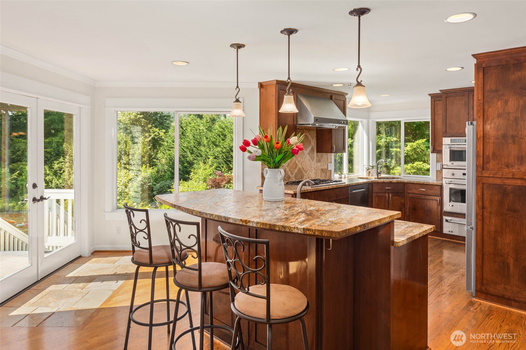 Kitchen with ample storage, stainless appliances, and a convenient eat-in bar.