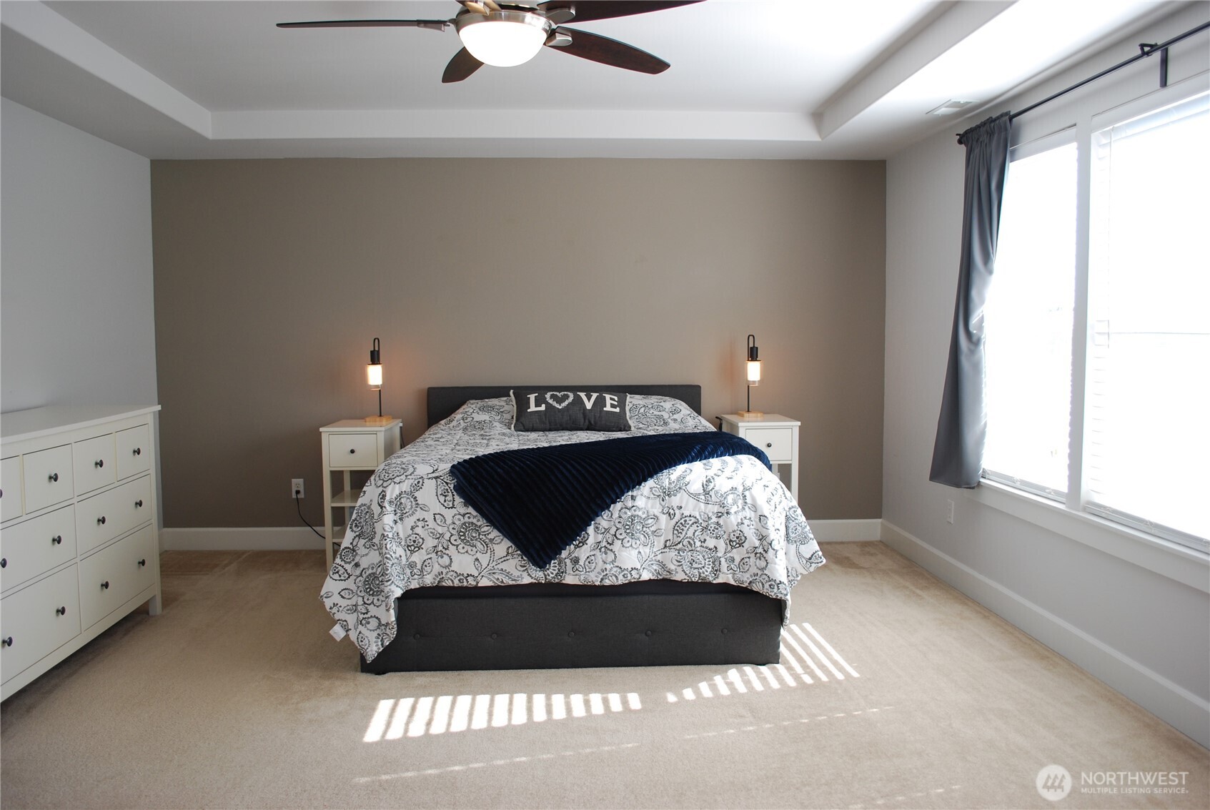 Large primary suite with ceiling fan and coffered ceiling.