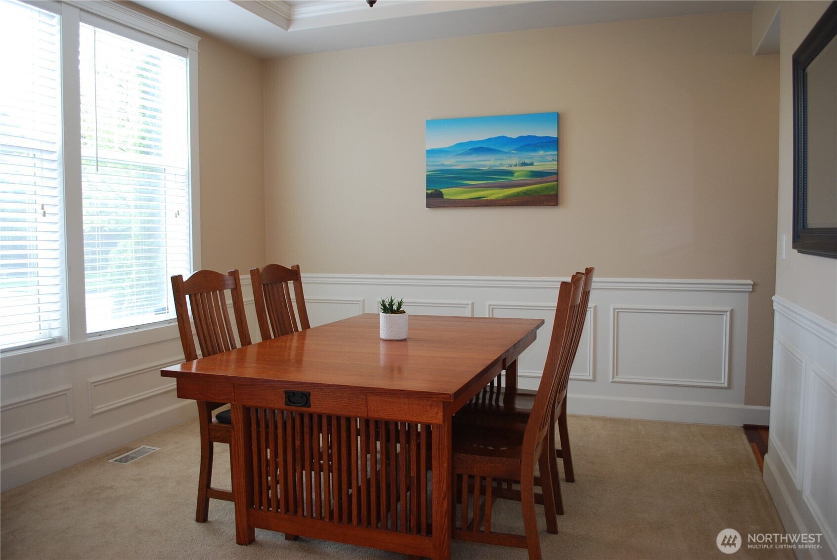 Large formal dining room with lots of natural sunlight, 9 foot coffered ceilings, half wall panel style moldings, and a butler's pantry joining it to the kitchen.
