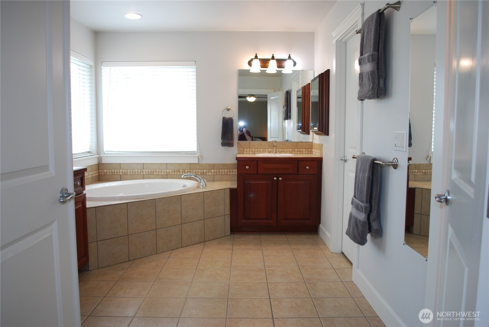 Bathroom suite features separate vanities, soaker tub, shower, private privy, and a walk in closet.