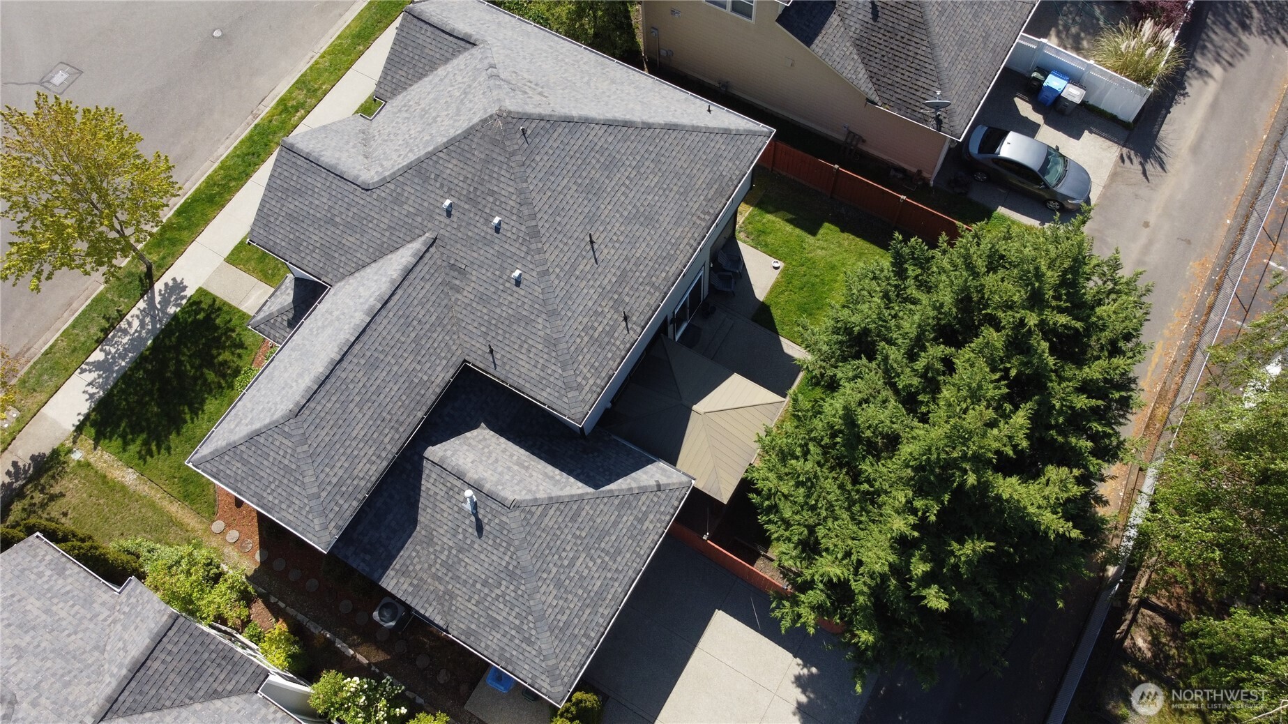 Aerial view of impressive exterior with mature landscaping, washed aggregate walkways, designer paint, covered front entry, and rear patio with cover.