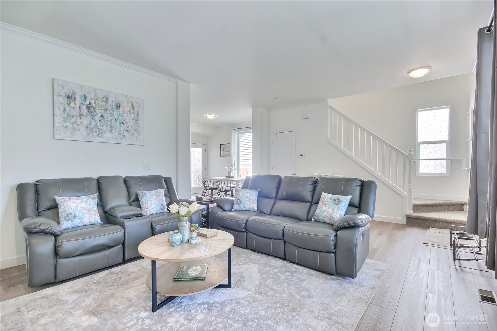 What an inviting living room space!   Open rail staircase leads upstairs.
