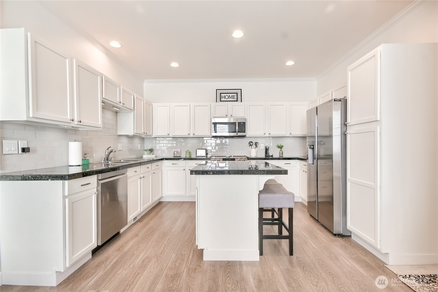 Gorgeous updated kitchen with granite counters, white cabinets, stainless steel appliances & beautiful LVP throughout the main floor.