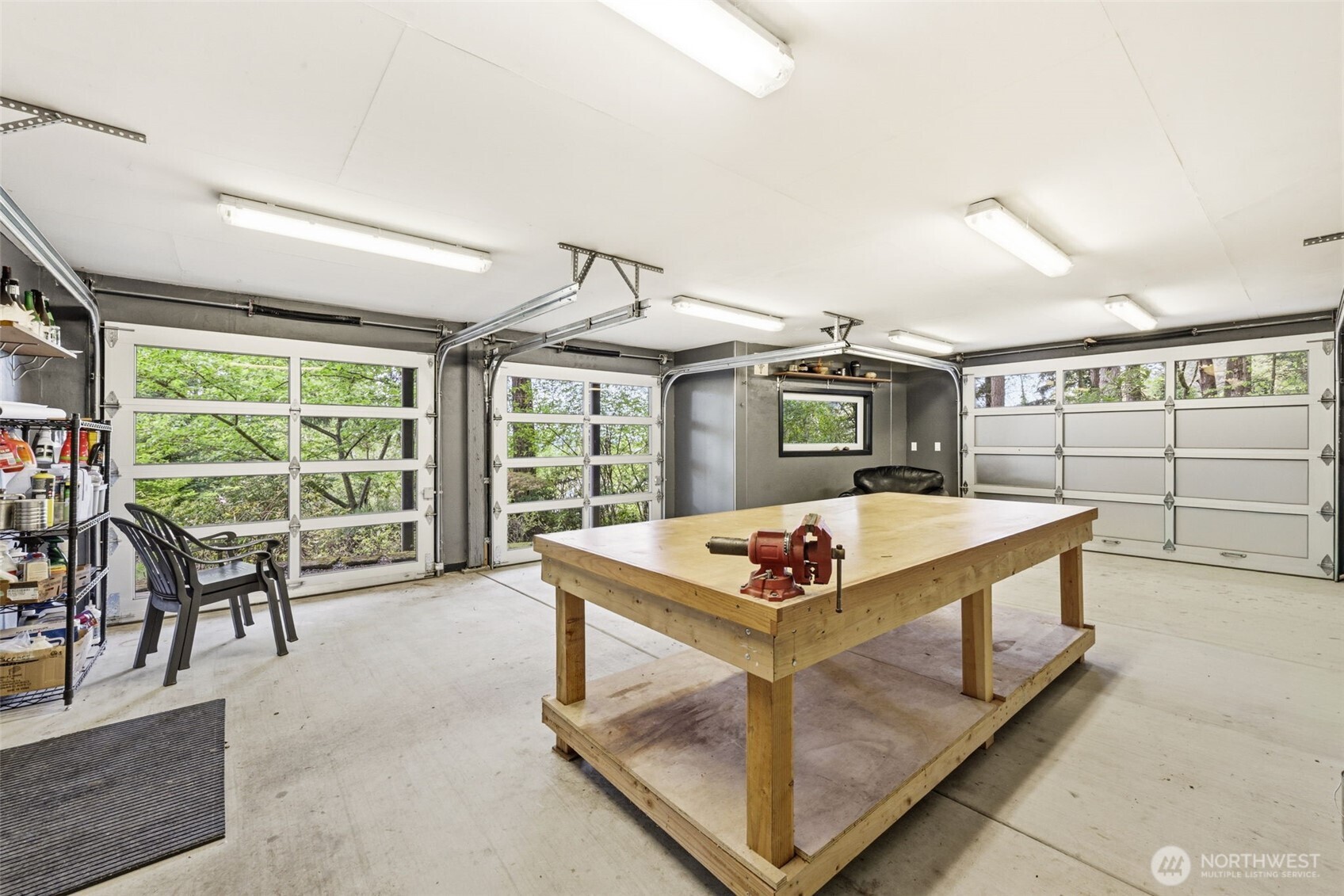 Workshop features full roll-up doors for a true connection to the outdoors, plus extensive storage running the full length of the home.