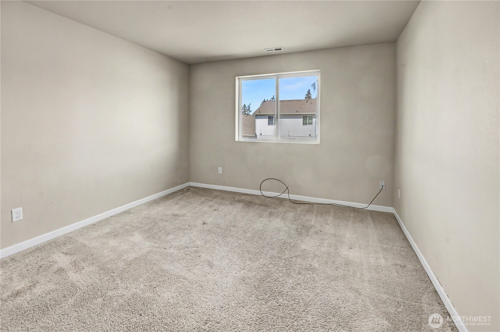 Bedroom on upper level with carpet flooring at back of house.
